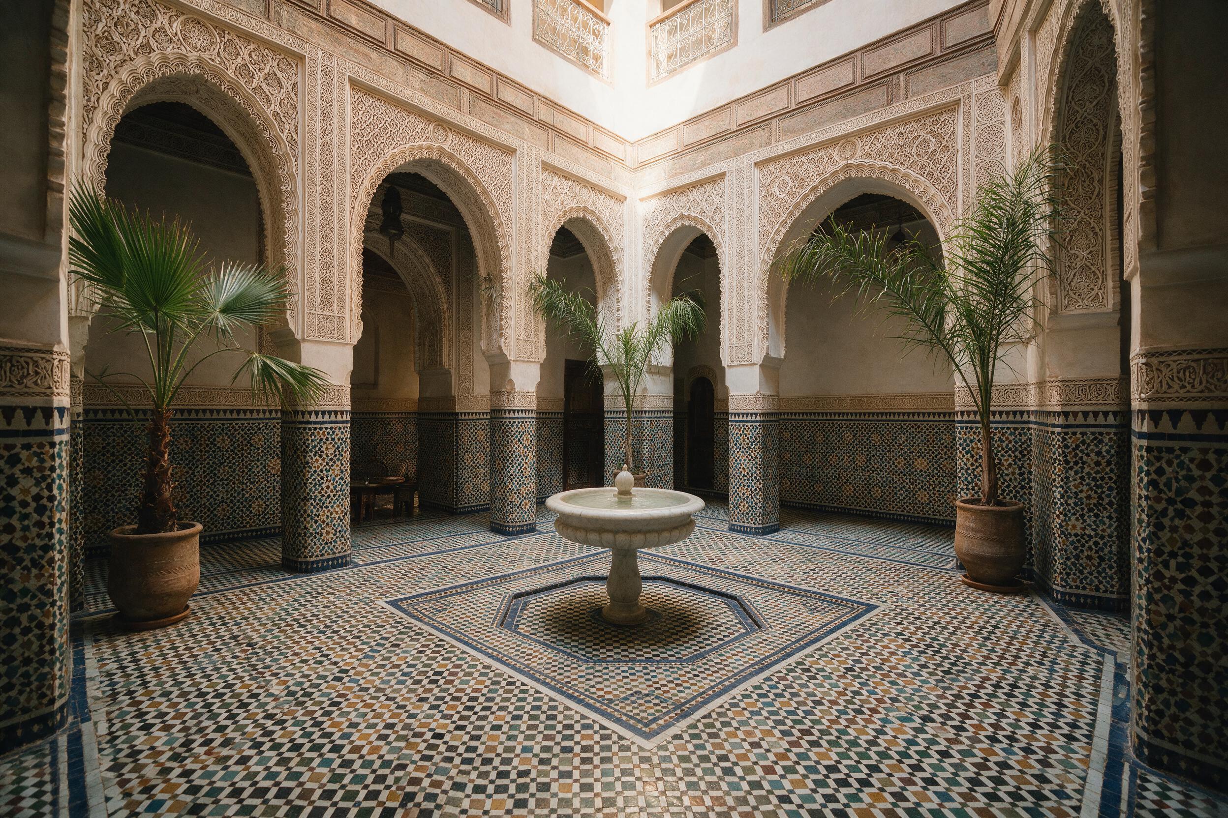 Quiet riad courtyard in Fes with traditional zellige tilework and a central fountain