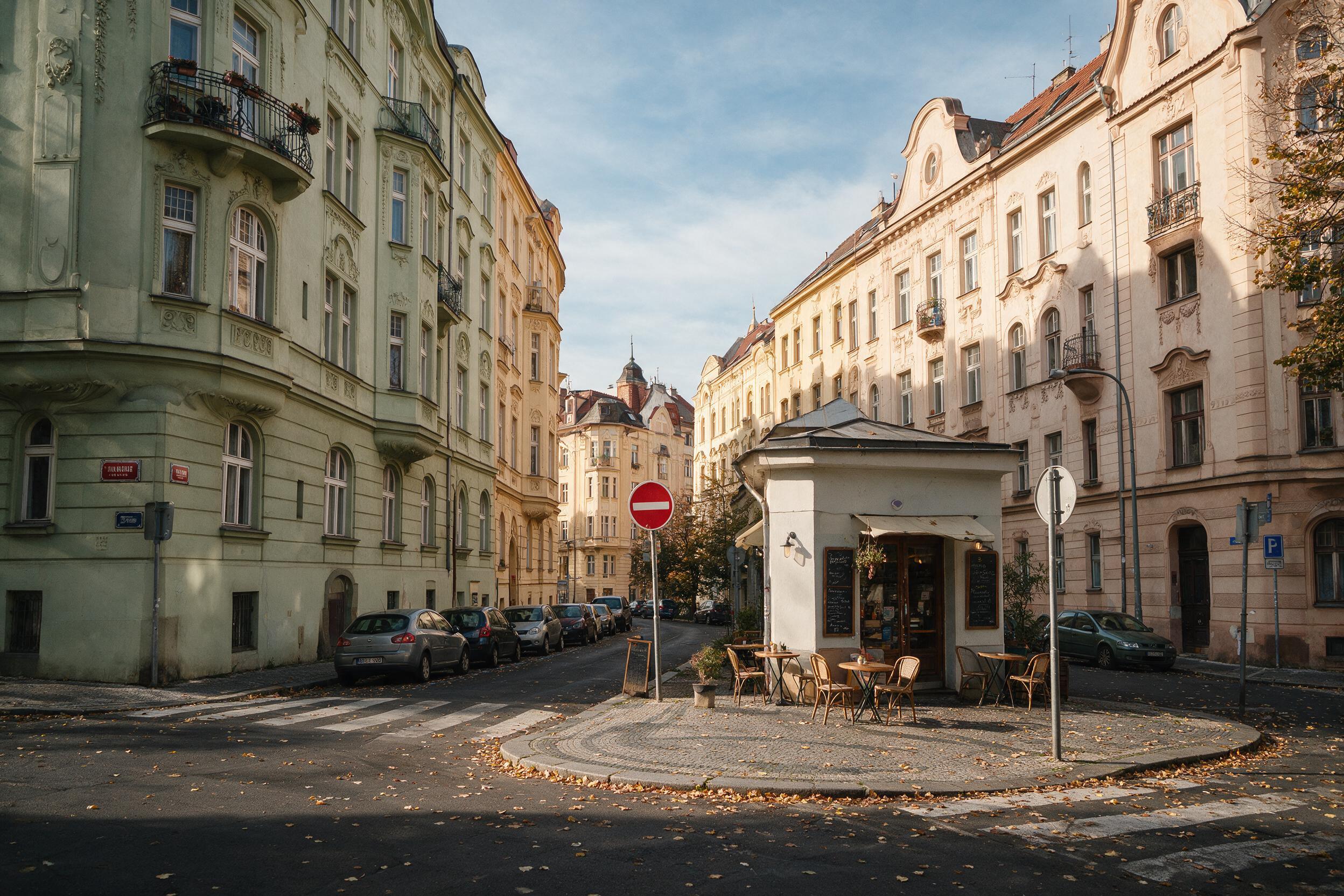 Quiet Art Nouveau street in Prague's Vinohrady neighborhood with a corner cafe
