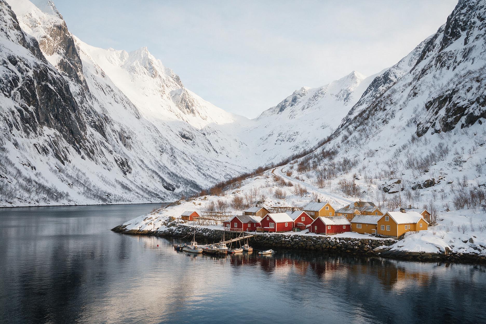 Ersfjordbotn fjord village near Tromsø with traditional Norwegian houses and snow-capped peaks