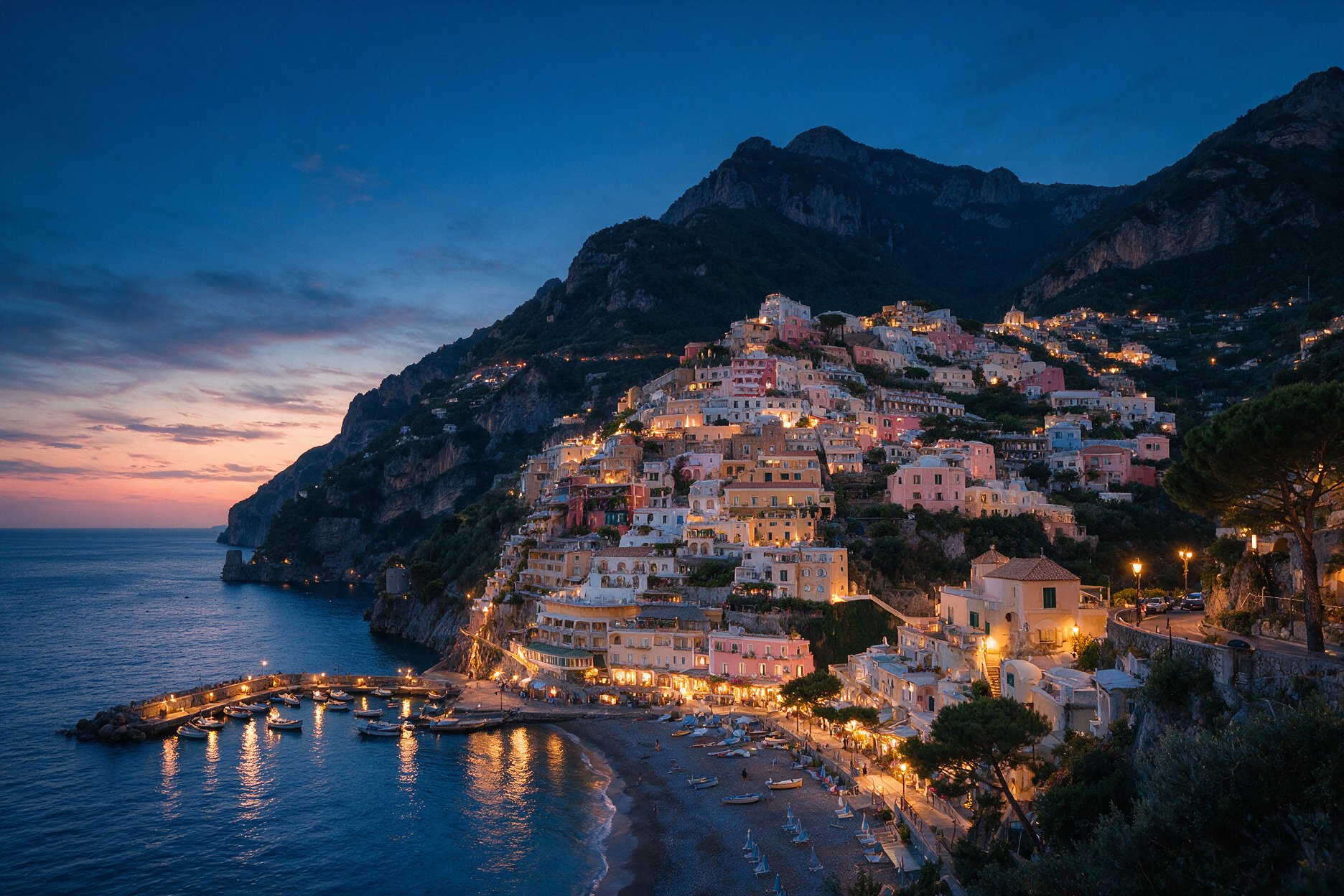 Positano on the Amalfi Coast during blue hour just after sunset, with town lights beginning to glow