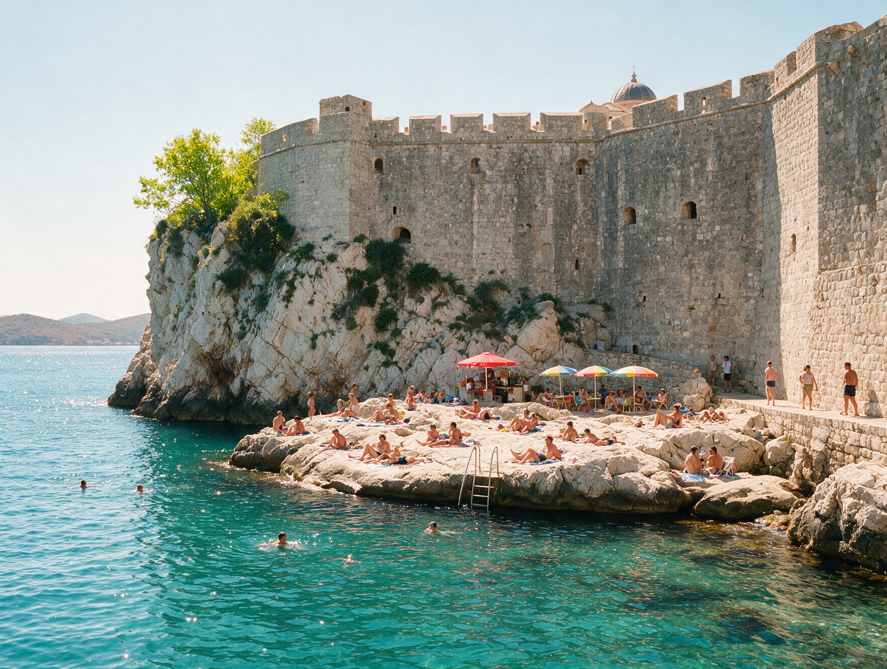 People swimming from the rocky cliffs below Dubrovnik's sea walls near Buza Bar