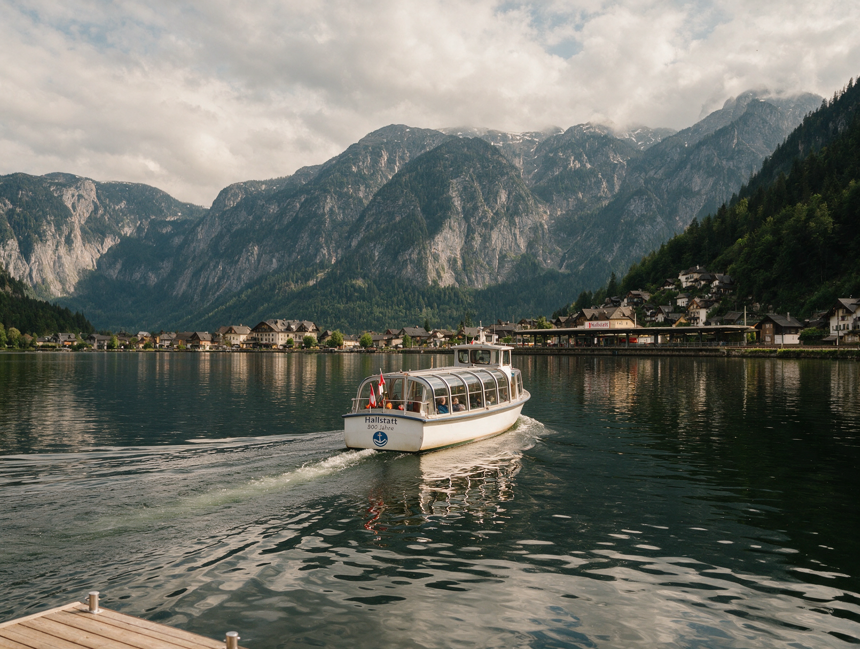 A small ferry boat crossing Lake Hallstatt toward the village train station