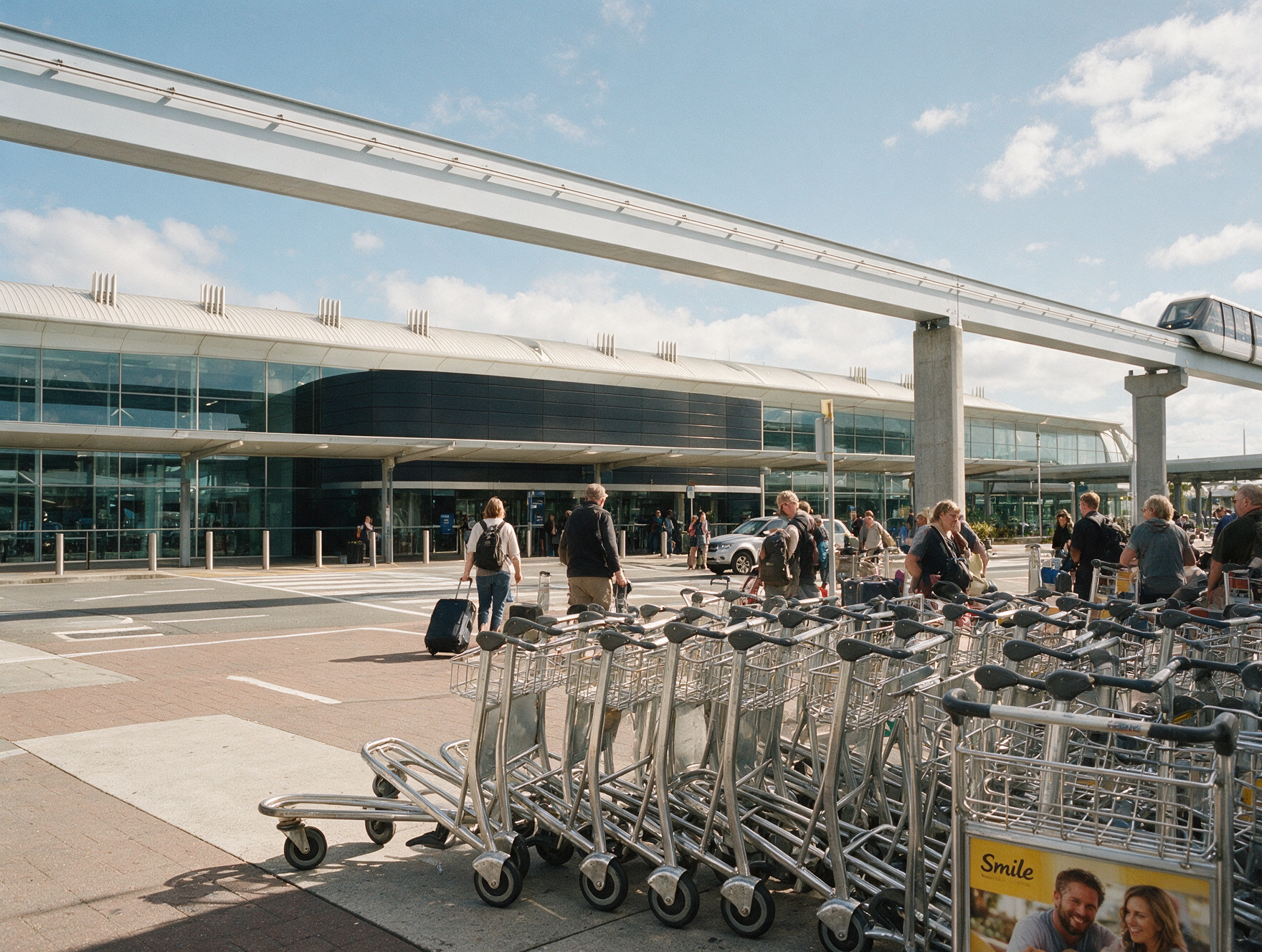 Travelers arriving at Auckland International Airport with luggage after a long haul flight from India